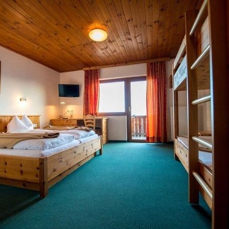 Gemütliches Zimmer mit zwei Etagenbetten und einem Fernseher im Vordergrund