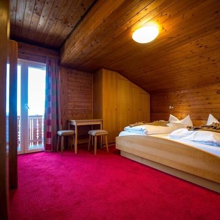 Ein Schlafzimmer mit einem gemütlichen Bett und einer rustikalen Holzdecke