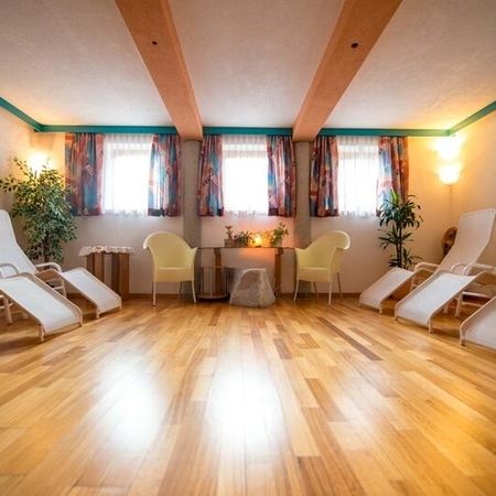 Heller Ruheraum mit weißen Liegen und einem Tisch, perfekt für Erholung und Ruhe