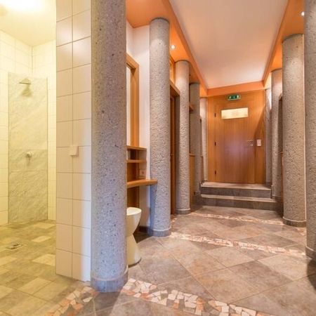 Badezimmer mit Toilette, Waschbecken und Dusche, hell und modern eingerichtet.