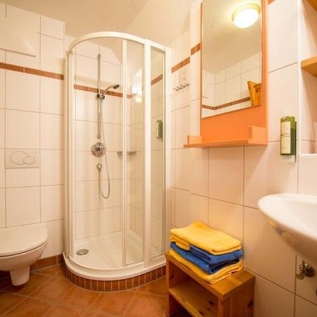 Badezimmer mit modernen Armaturen und hellen Fliesen.