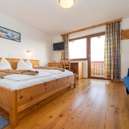 Gemütliches Zimmer mit einem Bett und einer Couch, die vor einem großen Fenster stehen