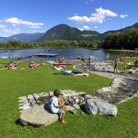 Urlaub liegen auf dem Gras und genießen die Sonne in der Nähe eines ruhigen Sees.